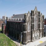 A gothic stone church seen from the roof of a building across the street.