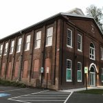 A large brick building with a gable roof.